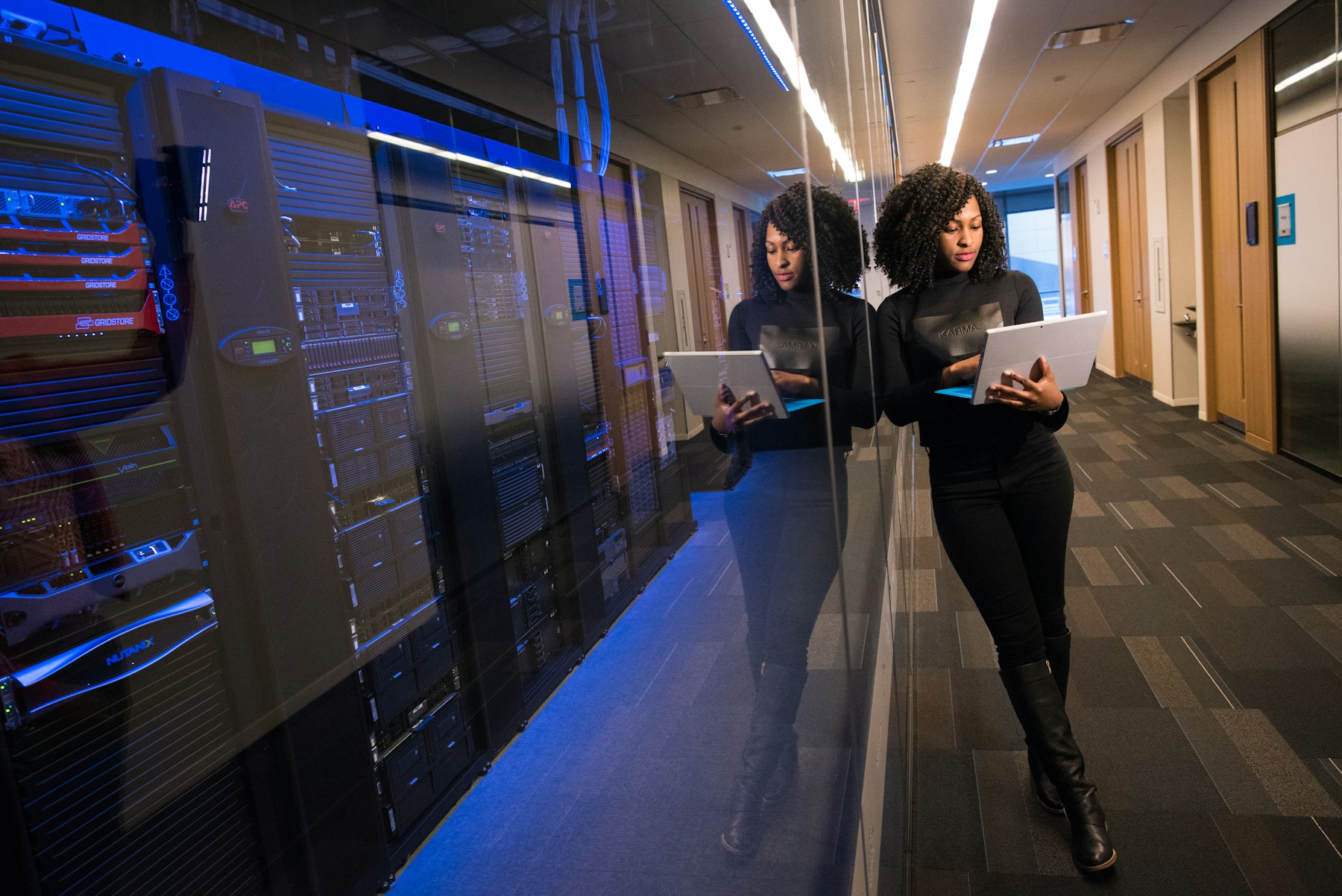 Energy professional reviewing data near a server and control infrastructure rack